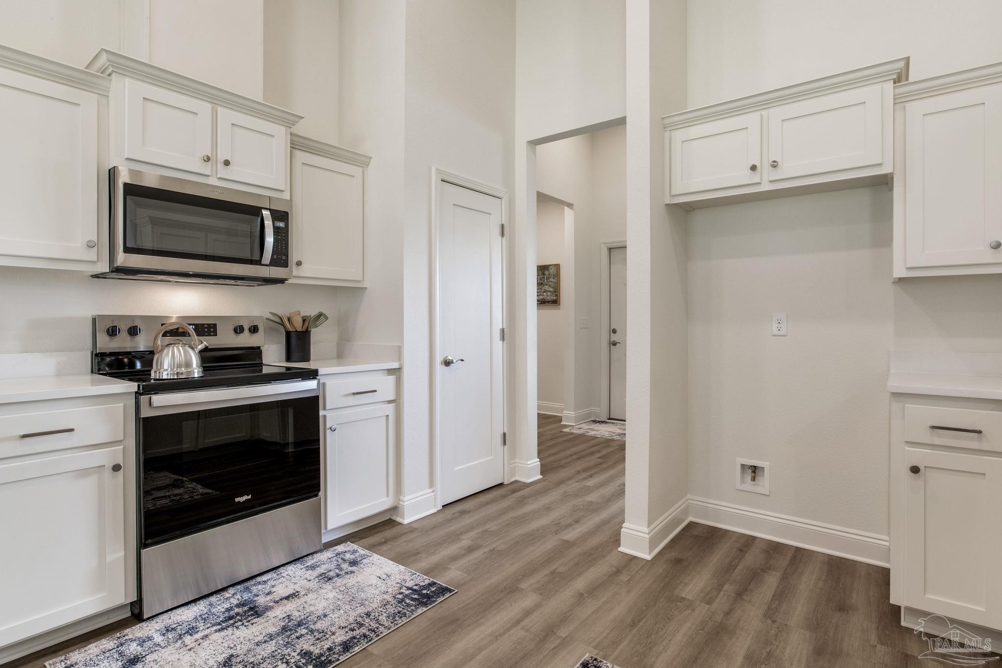 4404 Russell Elliott Road Jay, FL 32565 - Photo 16 of 62 a kitchen with stainless steel appliances white cabinets and a stove top oven