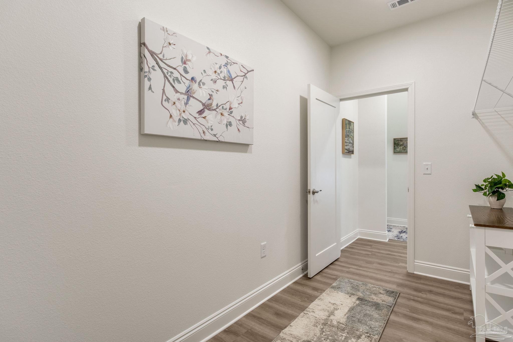 4404 Russell Elliott Road Jay, FL 32565 - Photo 49 of 62 a view of a hallway with wooden floor and a bathroom