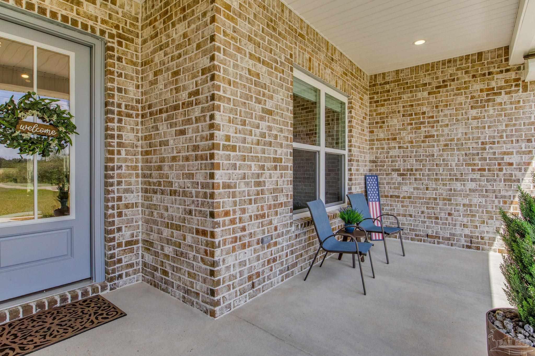 4404 Russell Elliott Road Jay, FL 32565 - Photo 6 of 62 a brick building with a bench and a potted plant