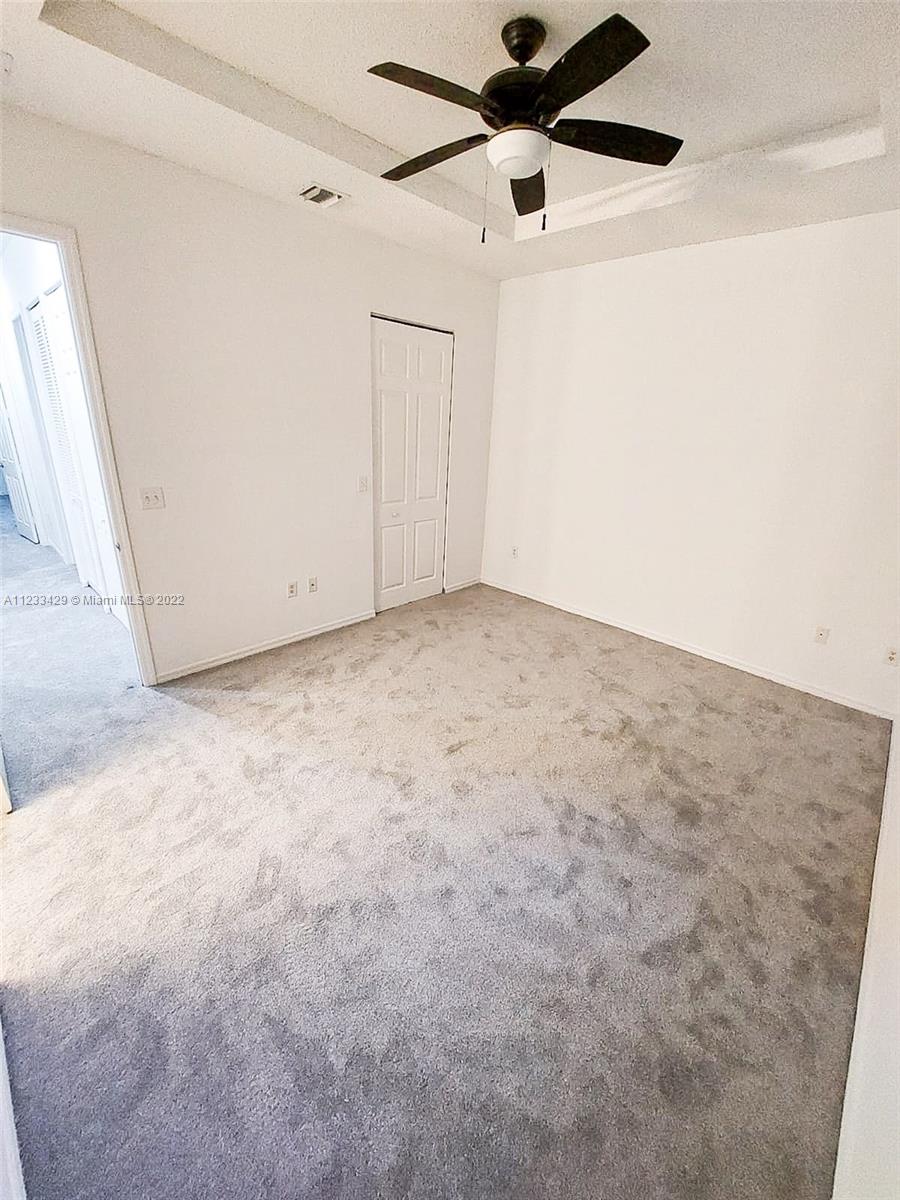 4282 Northeast 9th Street, Unit 4282 Homestead, FL 33033 - Photo 23 of 28 an empty room with a ceiling fan and carpet