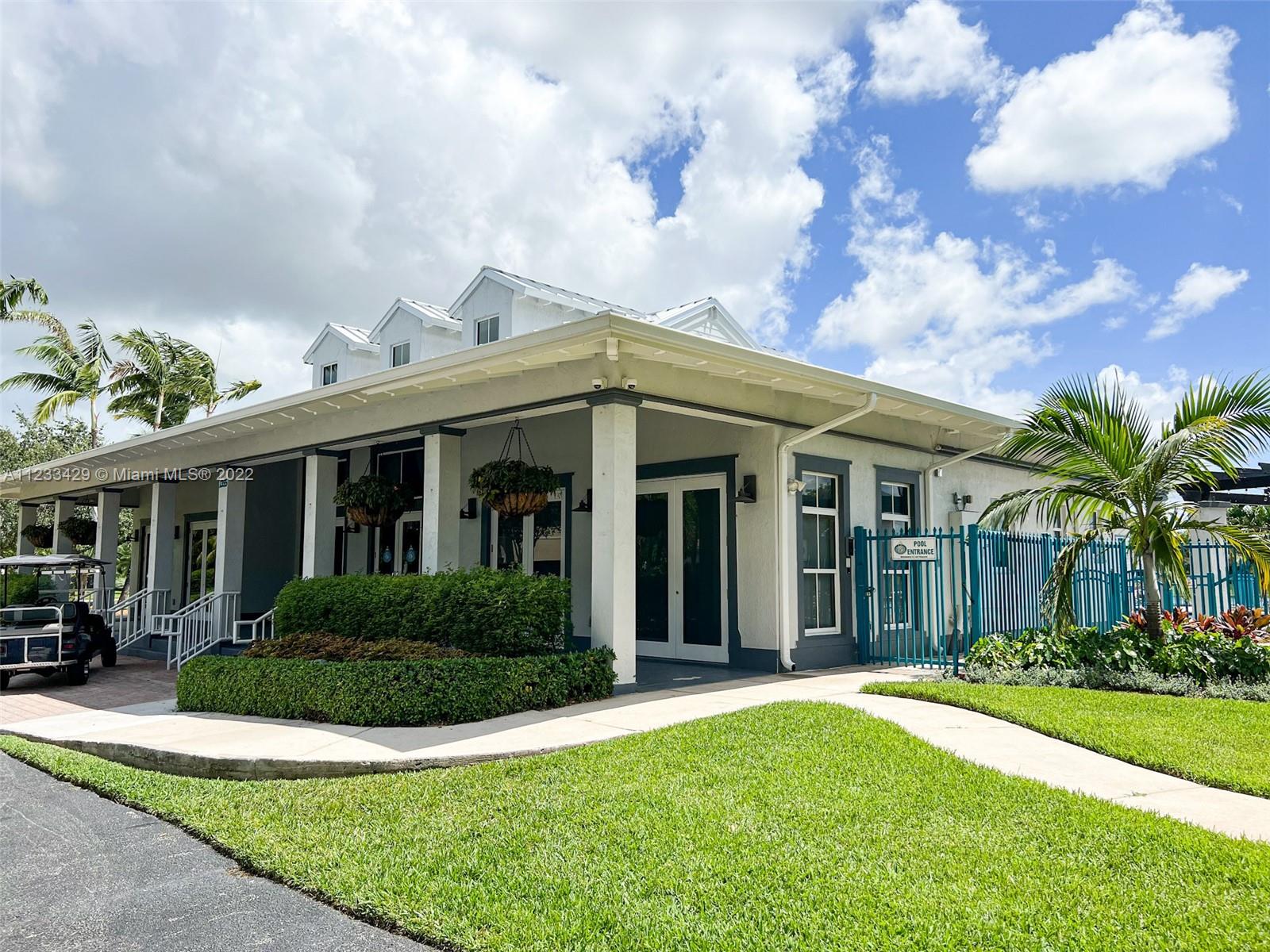 4282 Northeast 9th Street, Unit 4282 Homestead, FL 33033 - Photo 26 of 28 a view of a white house next to a yard with plants and trees