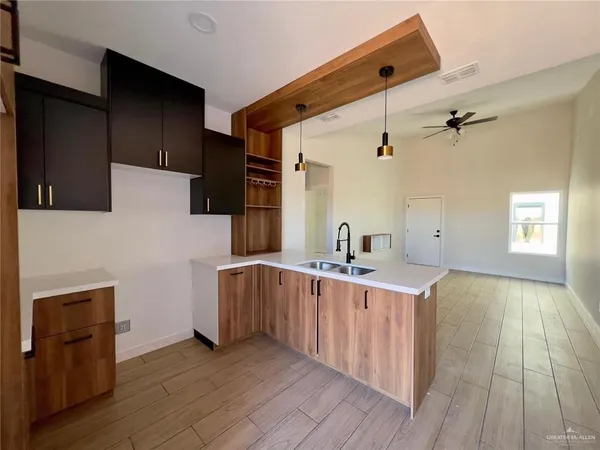 a kitchen with stainless steel appliances a sink and wooden floor
