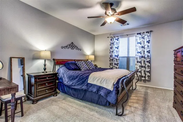 a spacious bedroom with a bed and a chandelier