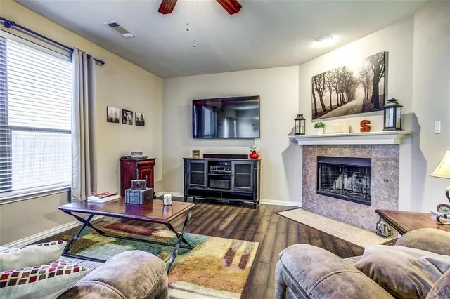 a living room with furniture a flat screen tv and a fireplace