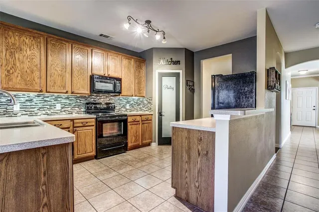 a kitchen with stainless steel appliances granite countertop wooden cabinets a stove top oven a sink and dishwasher