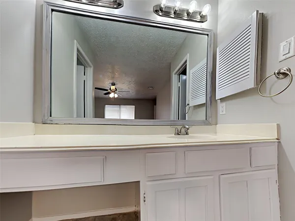 an empty room with wooden floor cabinet and windows
