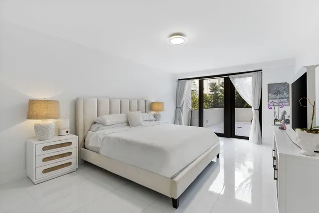 a bedroom with a large bed and a flat tv screen on the dresser