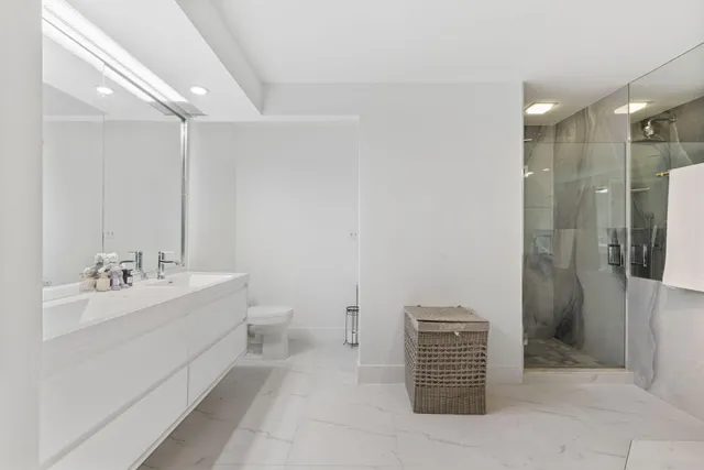 a bathroom with a sink a toilet and shower