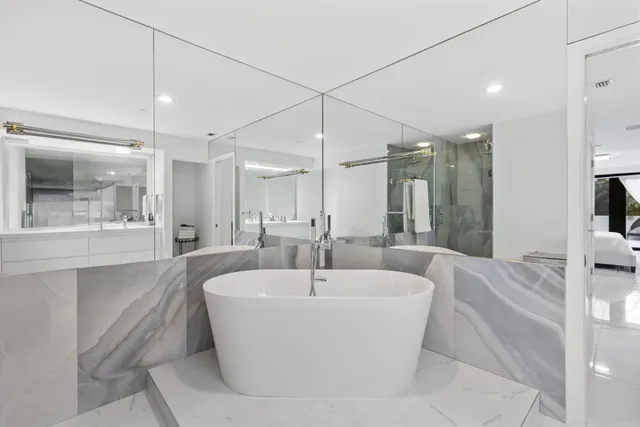 a large tub sitting next to a bathroom sink and a mirror