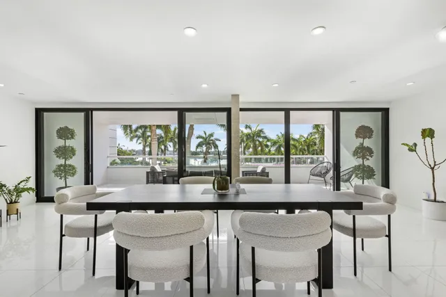 a dining room with stainless steel appliances granite countertop a table and chairs next to a large window