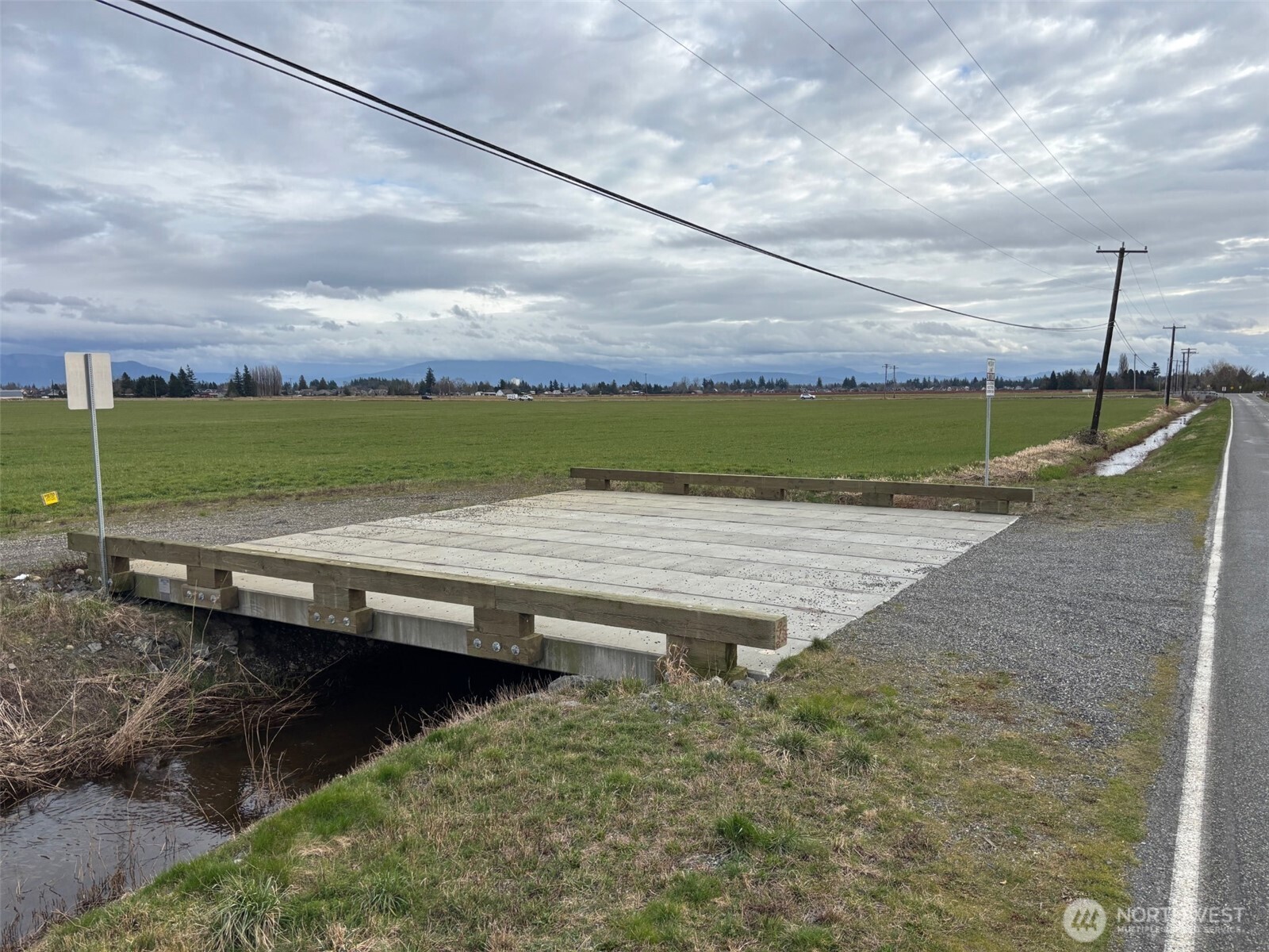 0 East Badger Road Lynden, WA 98264 - Photo 4 of 7 a view of a lake with a yard and a wooden fence
