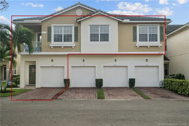 a front view of a house with a yard and a garage