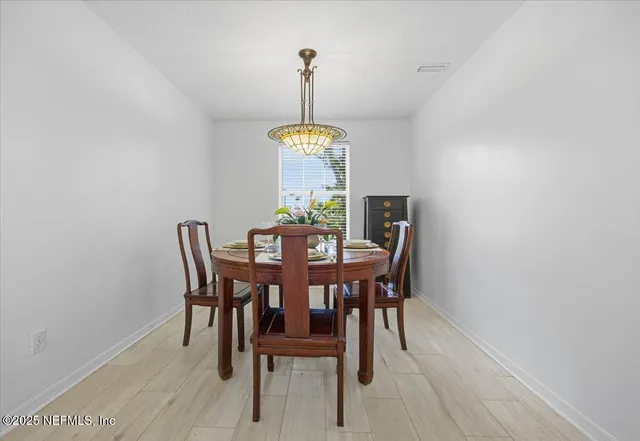 a dining room with a table chairs and a window
