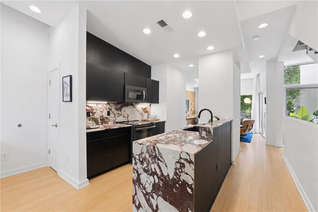 752 Moreland Avenue Southeast, Unit 4 Atlanta, GA 30316 - Photo 4 of 58 a kitchen with stainless steel appliances kitchen island granite countertop a sink and cabinets