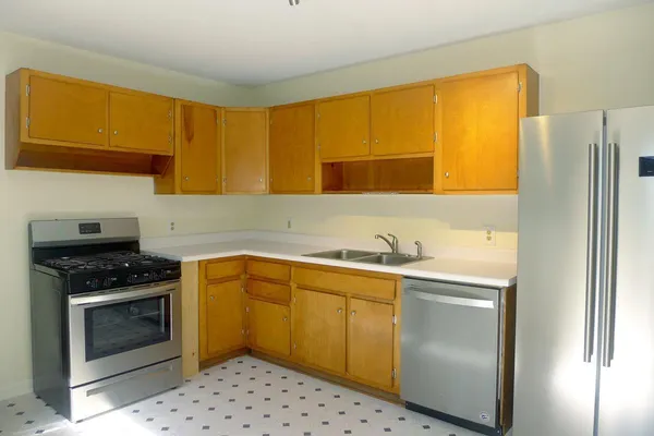 a kitchen with stainless steel appliances a stove a sink and a refrigerator