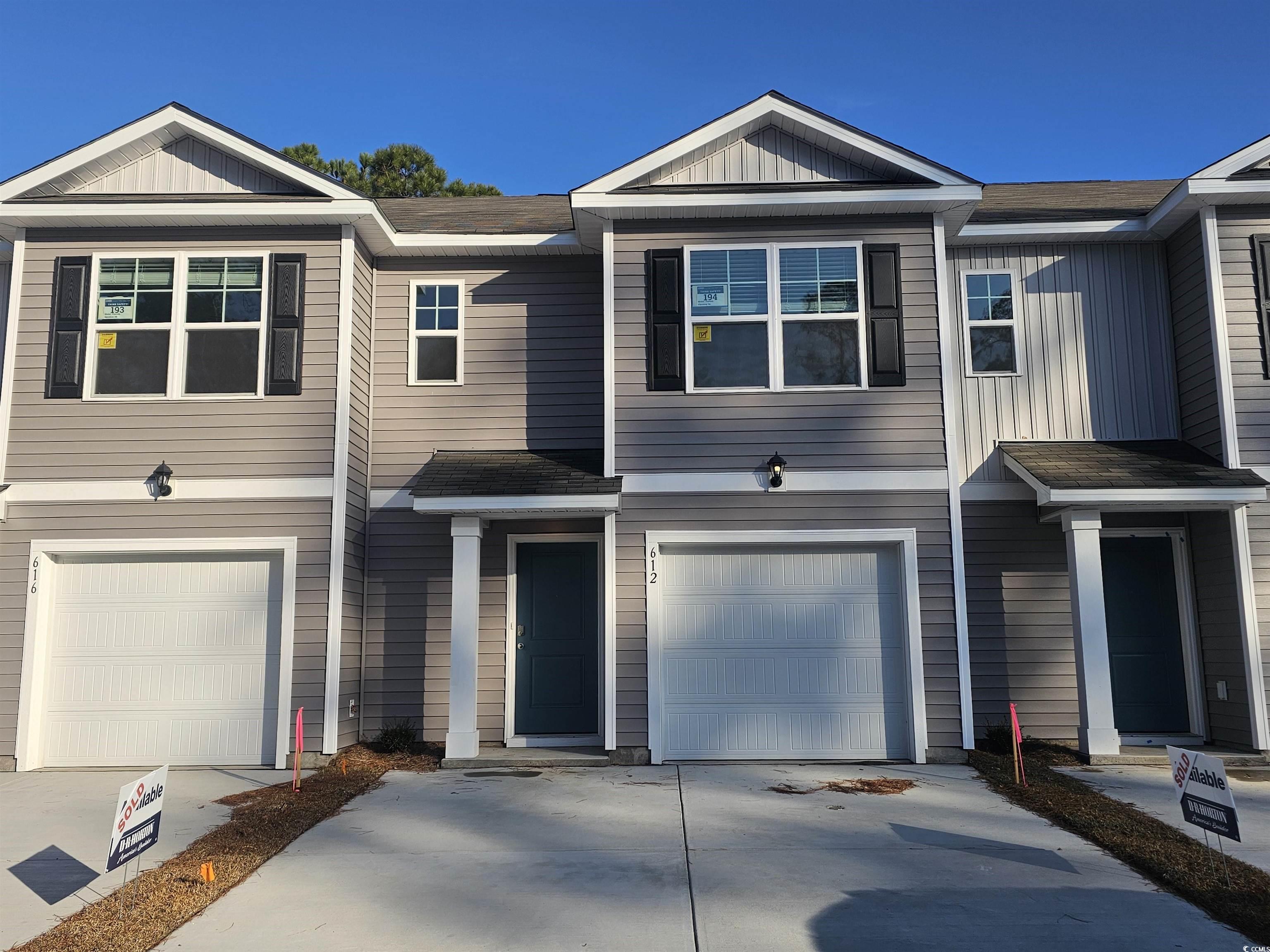 View of front of home featuring board and batten siding, an attached garage, and driveway
