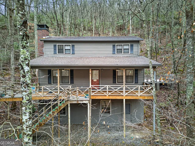 front view of a house with table chairs and wooden fence