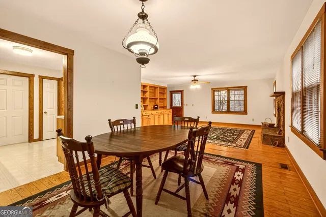 a dining room with furniture a chandelier and wooden floor