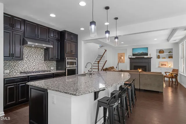 a kitchen with stainless steel appliances granite countertop a sink a stove and a refrigerator