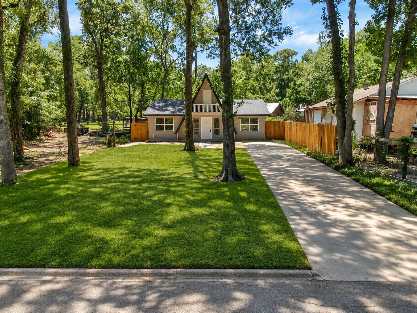 408 Commanche Road Conroe, TX 77316 - Photo 25 of 25 Charming A-frame home nestled among mature trees, featuring a spacious front yard and a private driveway for convenient parking.