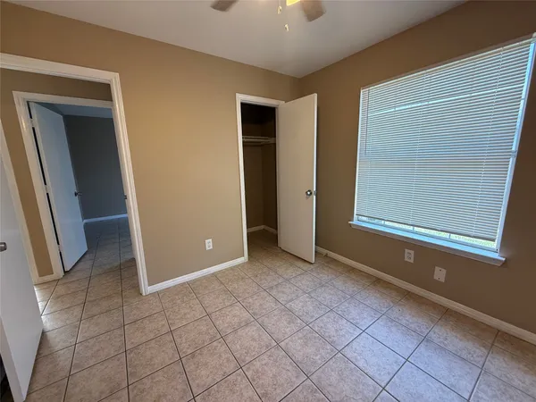 an empty room with windows and closet