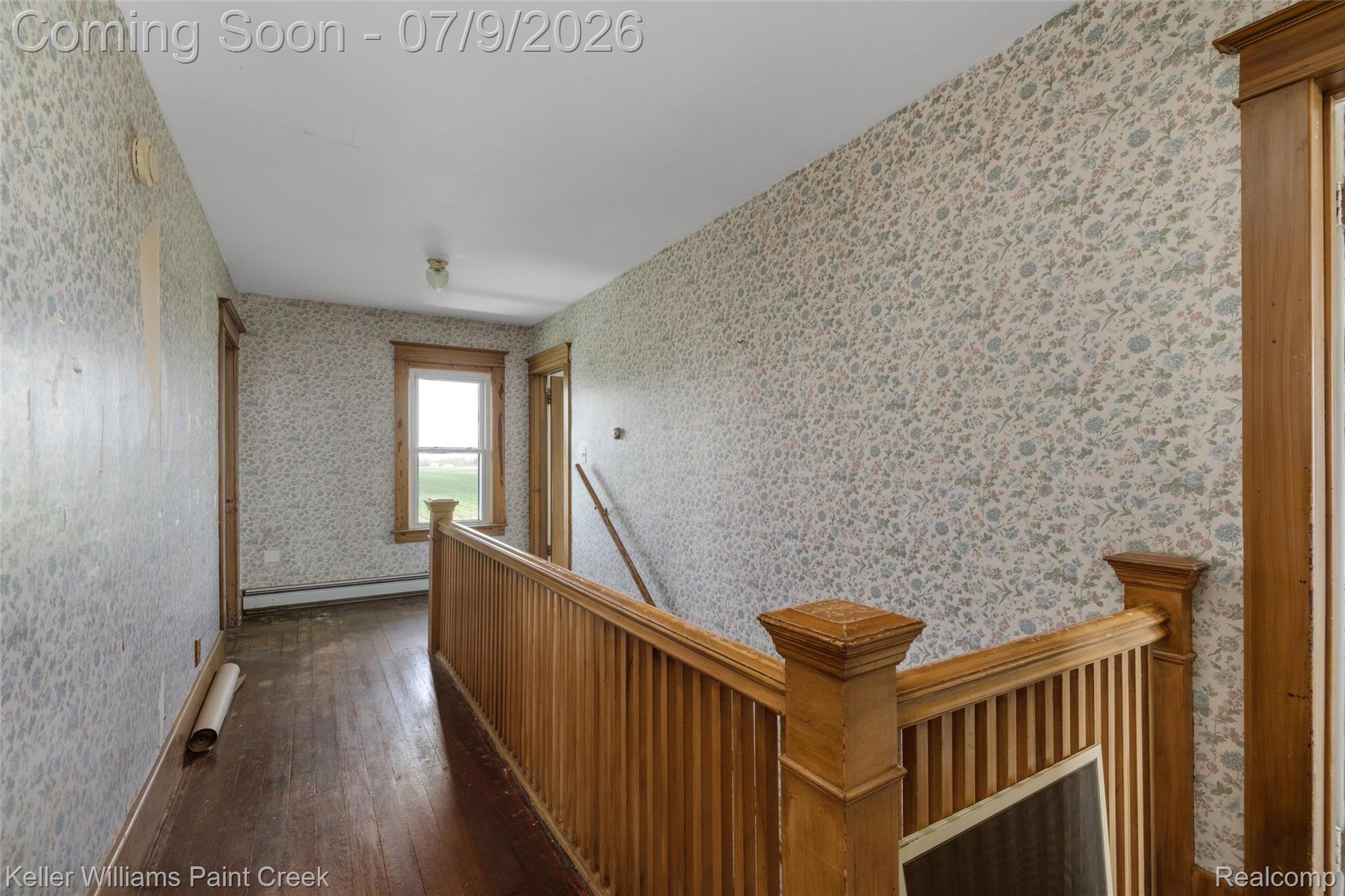 28780 School Section Road Richmond, MI 48062 - Photo 11 of 50 Hardwood flooring extends throughout this hallway, featuring a wooden staircase and balustrade
