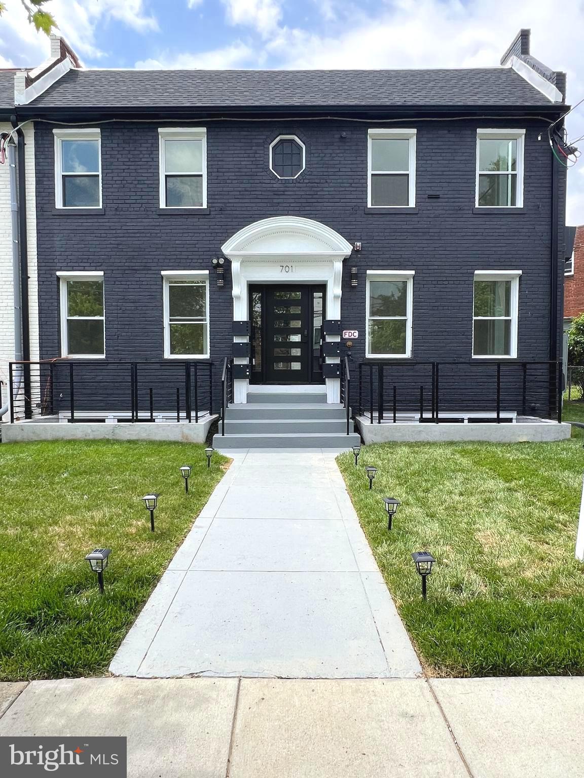 a front view of a brick house with a yard