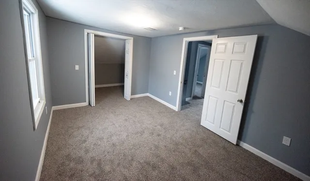 an empty room with windows and closet