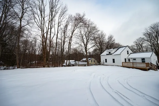 a view of white house with a yard covered in snow