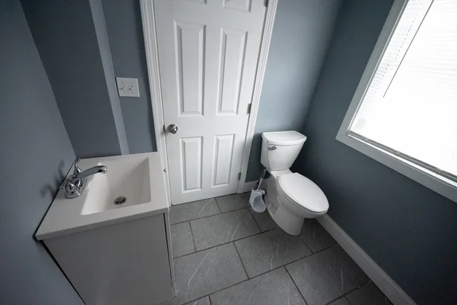 a bathroom with a toilet sink and mirror