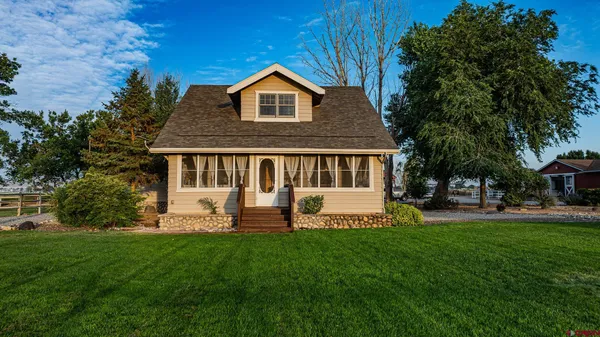 a front view of a house with a yard and trees