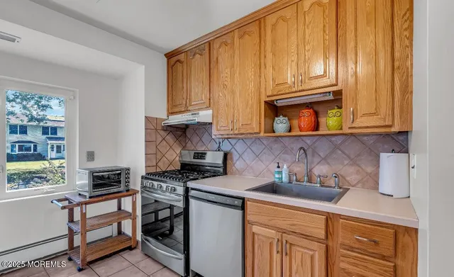 a kitchen with stainless steel appliances granite countertop a stove a sink and a microwave
