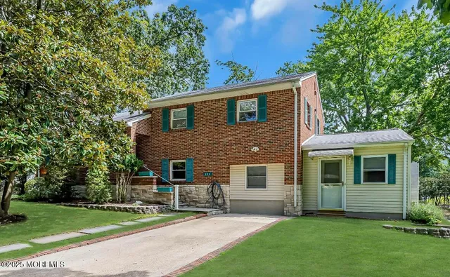 a front view of a house with a garden and yard