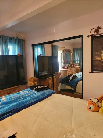 a bedroom with a bed and a flat screen tv