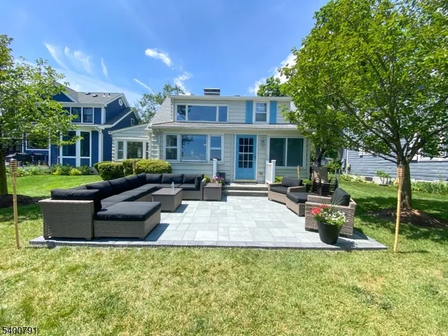 a view of a house with backyard sitting area and swimming pool