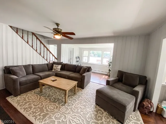 a living room with furniture a ceiling fan and a rug