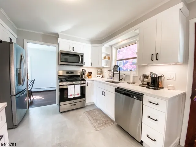 a kitchen with granite countertop a refrigerator stove and sink