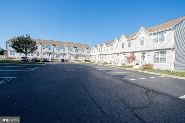 a view of a house with a small yard and wooden floor and fence