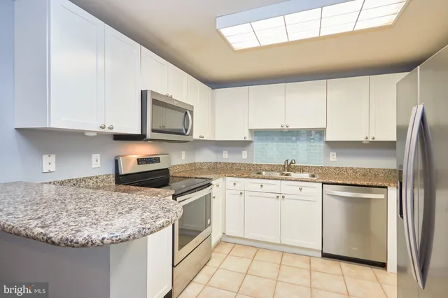 a kitchen with cabinets appliances and a counter space