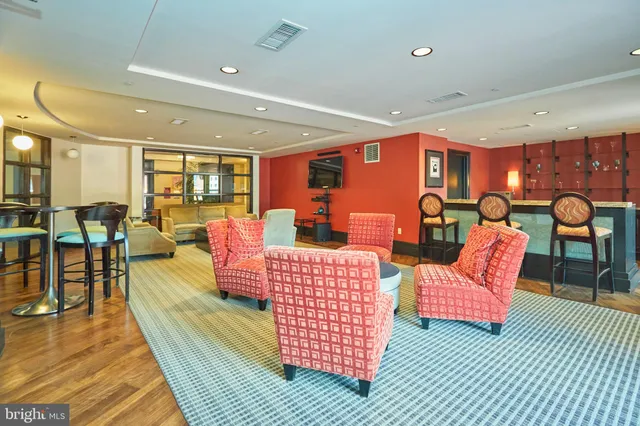 a living room with furniture a rug and kitchen view