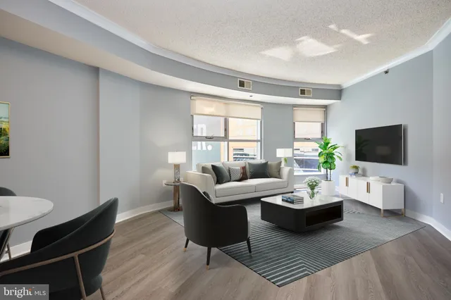 a living room with furniture a flat screen tv and a large window