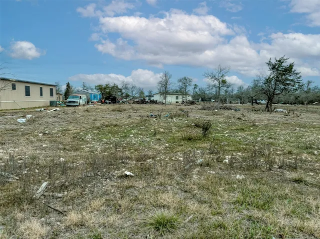 a view of a big yard with wooden fence