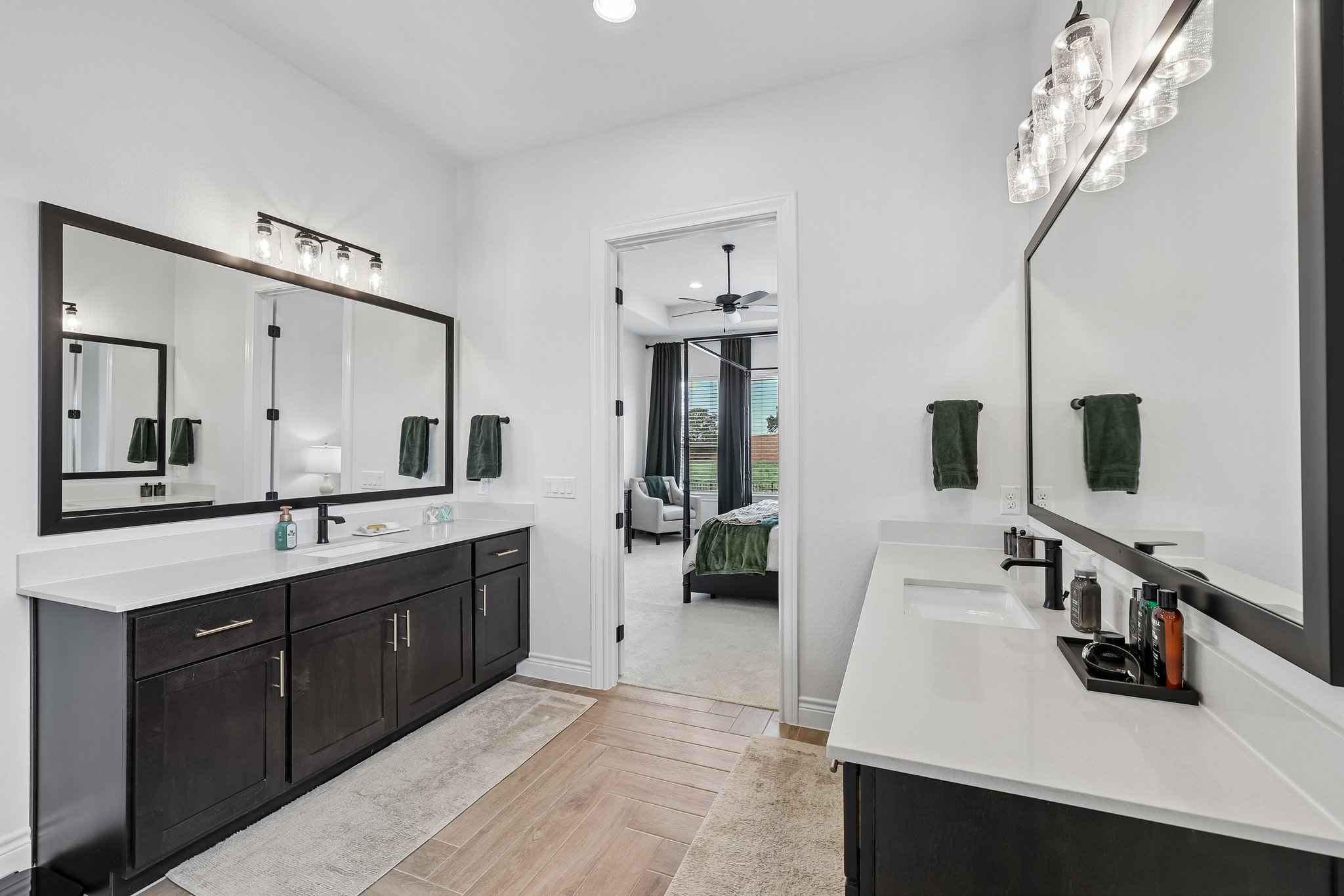 130 Firethorn Loop Bastrop, TX 78602 - Photo 23 of 38 Dual vanity bathroom featuring dark wood cabinetry and white countertops
