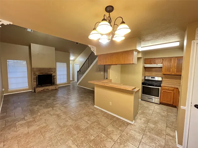a view of a kitchen with a sink and dishwasher a stove top oven with wooden floor
