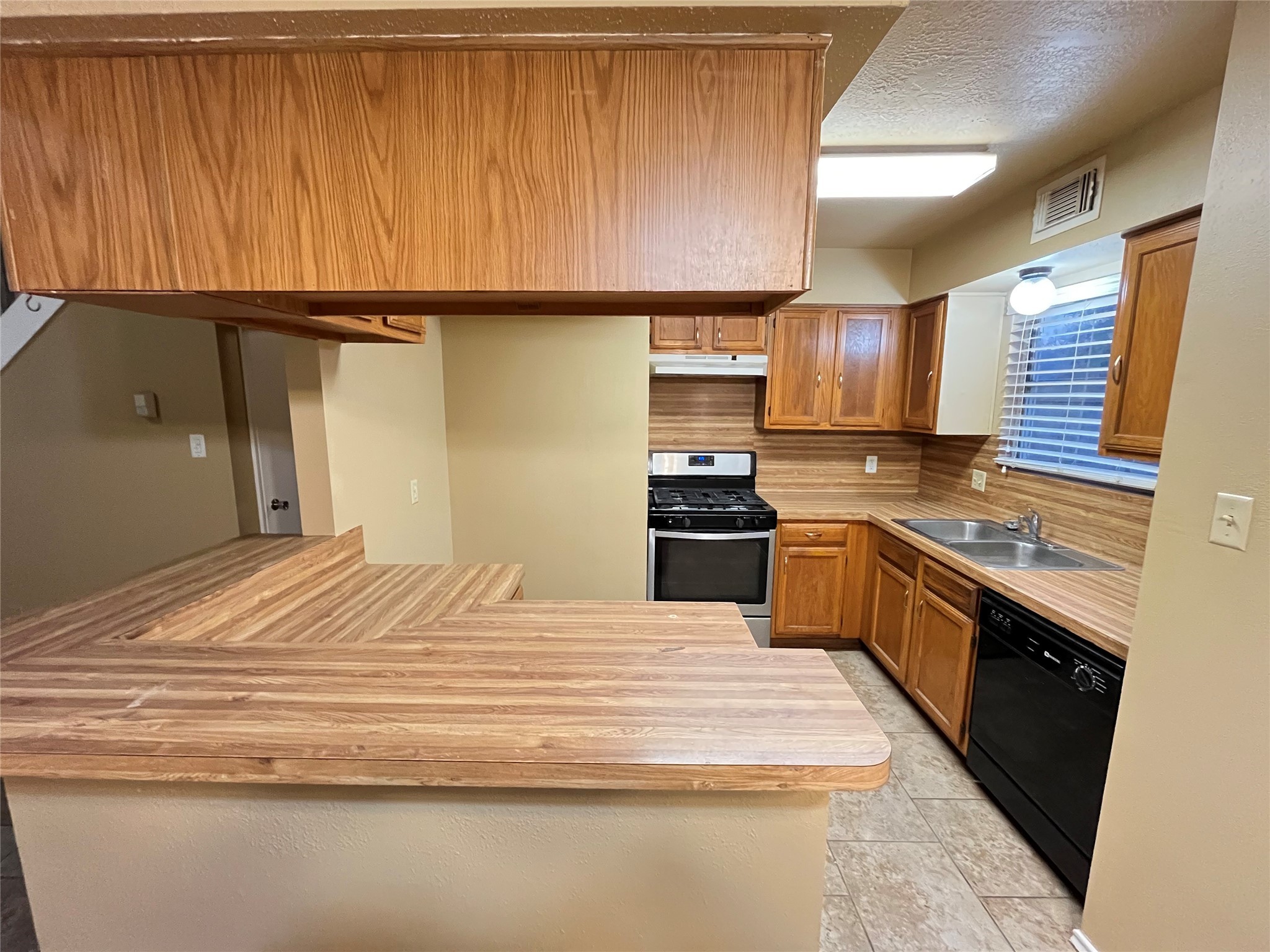 4906 Deer Point Drive Spring, TX 77389 - Photo 3 of 12 a kitchen with granite countertop wooden cabinets and stainless steel appliances