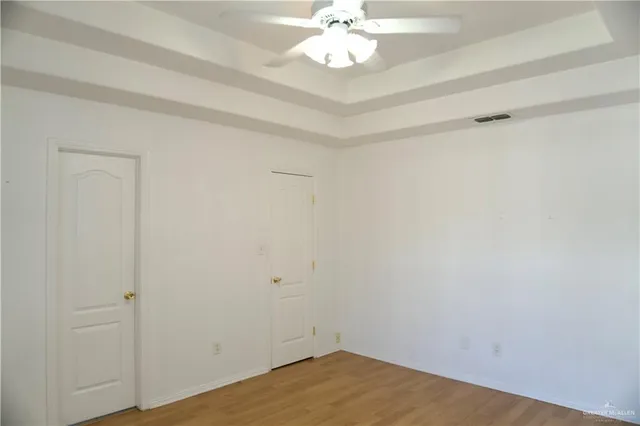 a view of a room with wooden floor and fan
