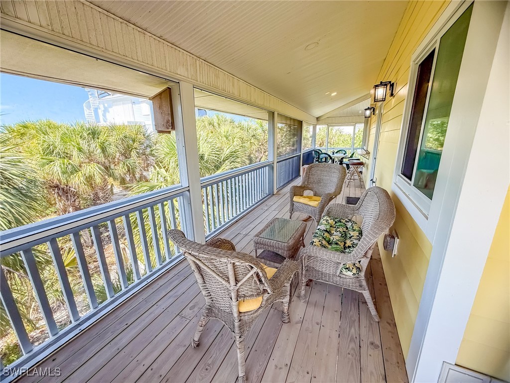 4511 Conch Shell Drive Upper Captiva, FL 33924 - Photo 16 of 50 a balcony with wooden floor and outdoor seating