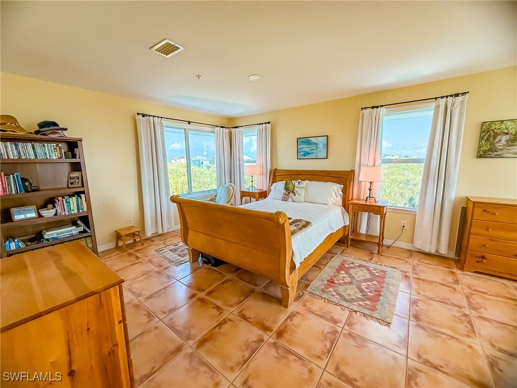 4511 Conch Shell Drive Upper Captiva, FL 33924 - Photo 27 of 50 a bedroom with a bed and a couch