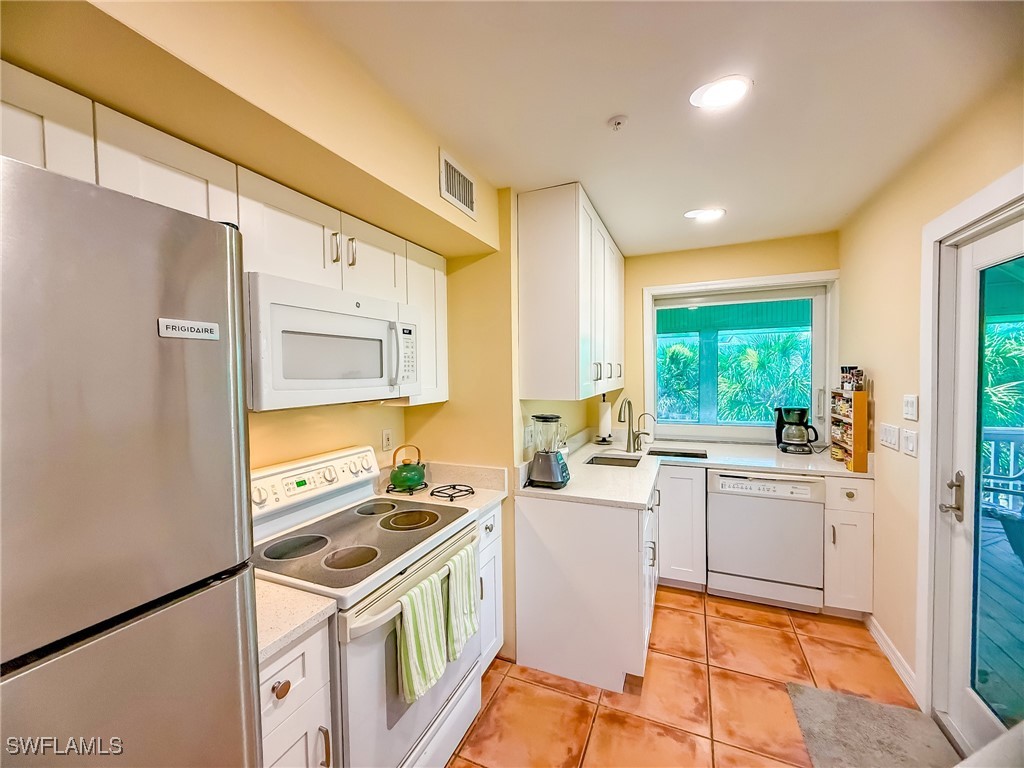 4511 Conch Shell Drive Upper Captiva, FL 33924 - Photo 7 of 50 a kitchen with a sink appliances cabinets and a large window
