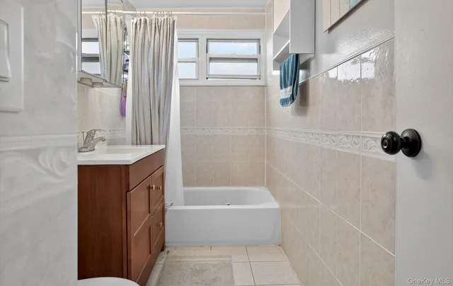 a bathroom with a bathtub a shower and a sink